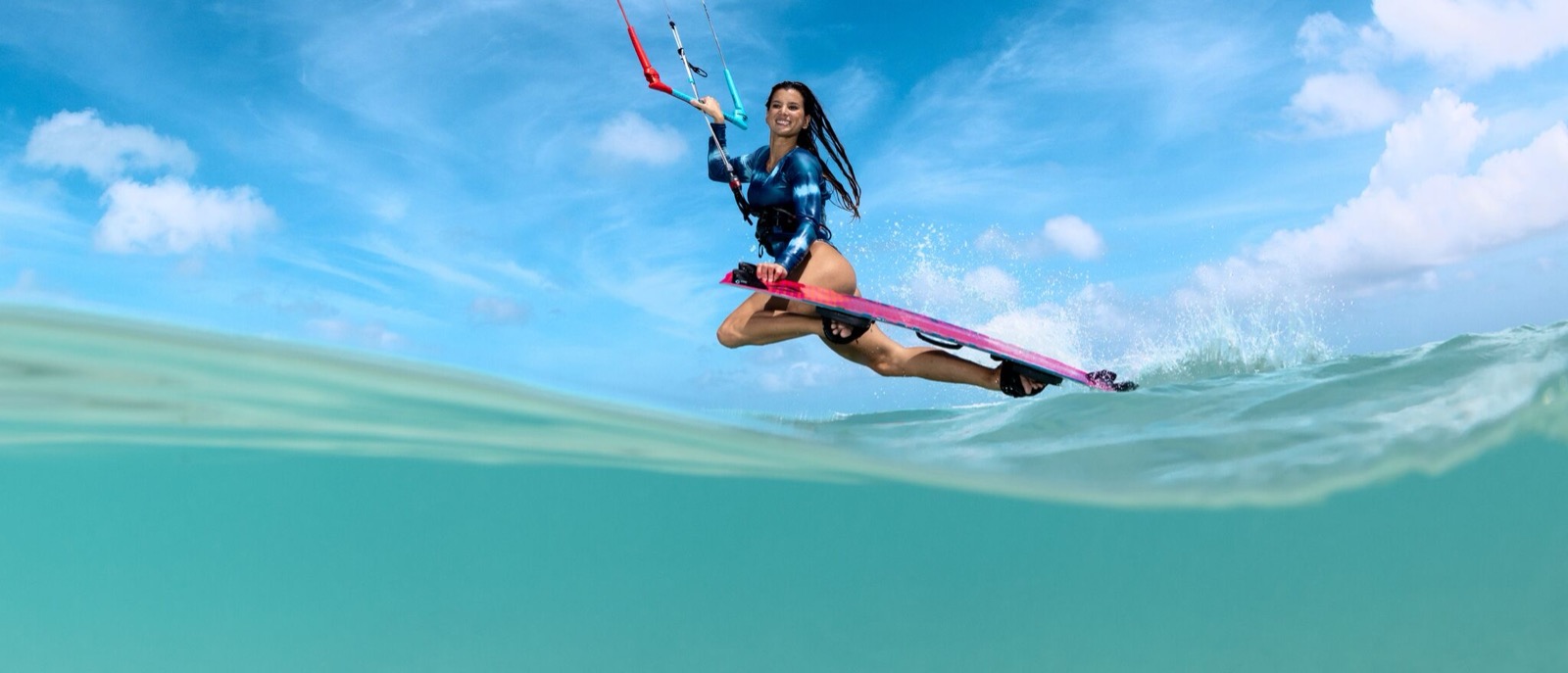 Kitesurfer jumping over turquoise water